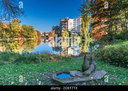 Berlin, Deutschland - 7. November 2020: Ufer des Lietzen Sees mit Gebäuden des Haus See-Eck und Ringhotel Seehof und der Steinskulptur zwei Seelöwen wi Stockfoto