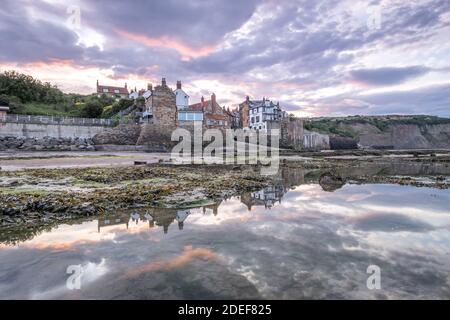 Sonnenuntergang über dem kleinen Fischerdorf Robin Hoods Bay, North Yorkshire Coast Stockfoto