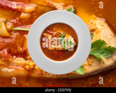 Fischsuppe in weißer Platte auf verschwommenem Hintergrund. Overhead-Ansicht. Stockfoto