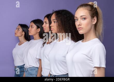 Gruppe Ernsthafter Multikultureller Frauen, Die In Reihe Stehen, Lila Hintergrund Stockfoto