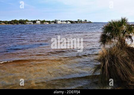 Eine schöne Aussicht auf das Festland von der gegenüberliegenden Küste des Golfs von Mexiko, von Santa Rose Island, das blaue Wasser des Ozeans glänzen mit dem bräunlichen Stockfoto