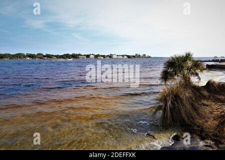 Eine schöne Aussicht auf das Festland von der gegenüberliegenden Küste des Golfs von Mexiko, von Santa Rose Island, das blaue Wasser des Ozeans glänzen mit dem bräunlichen Stockfoto