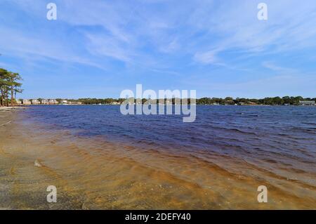 Eine schöne Aussicht auf das Festland von der gegenüberliegenden Küste des Golfs von Mexiko, von Santa Rose Island, das blaue Wasser des Ozeans glänzen mit dem bräunlichen Stockfoto