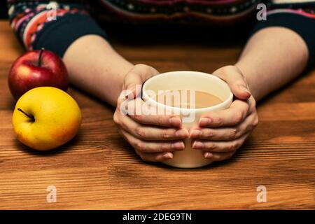 Junge Frau hält heißen Kakao oder Kaffee c. Herbst oder Winter launisch Wochenende, Neujahr und Weihnachten Hintergrund. Fauler Tag, Quarantäne, zu Hause bleiben, gemütlich Stockfoto