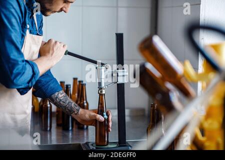 Getränkeproduktion, Mitarbeiter arbeitet an der Bierherstellung, Handwerksbetrieb Stockfoto