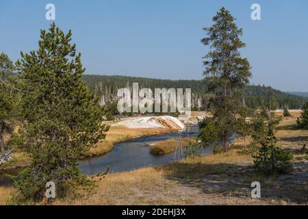 Der Firehole River fließt durch das Upper Geyser Basin des Yellowstone National Park in Wyoming, USA. Thermophile Mikroben machen bunte Matten Stockfoto