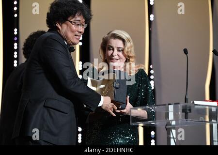 Der südkoreanische Regisseur Bong Joon-Ho (L) erhält von der französischen Schauspielerin Catherine Deneuve den Palme d'Or-Preis für den Film 'Parasite (Gisaengchung)', wie Alejandro Gonzalez Inarritu am 25. Mai als mexikanischer Regisseur und Jurypräsident der Filmfestspiele von Cannes ansieht. 2019 während der Abschlussfeier der 72. Ausgabe des Filmfestivals von Cannes in Cannes, Südfrankreich. Foto von David Niviere/ABACAPRESS.COM Stockfoto