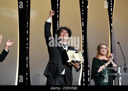 Der südkoreanische Regisseur Bong Joon-Ho (L) erhält von der französischen Schauspielerin Catherine Deneuve den Palme d'Or-Preis für den Film 'Parasite (Gisaengchung)', wie Alejandro Gonzalez Inarritu am 25. Mai als mexikanischer Regisseur und Jurypräsident der Filmfestspiele von Cannes ansieht. 2019 während der Abschlussfeier der 72. Ausgabe des Filmfestivals von Cannes in Cannes, Südfrankreich. Foto von David Niviere/ABACAPRESS.COM Stockfoto