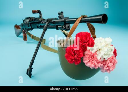 Maschinengewehr und Blumen in einer Armee Helm Stockfoto