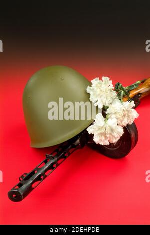 Maschinengewehr und Blumen in einer Armee Helm Stockfoto