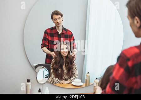 Stylist Friseur Styling lange Haare für schöne asiatische junge Frau im Schönheitssalon, Arbeitsmoment Stockfoto