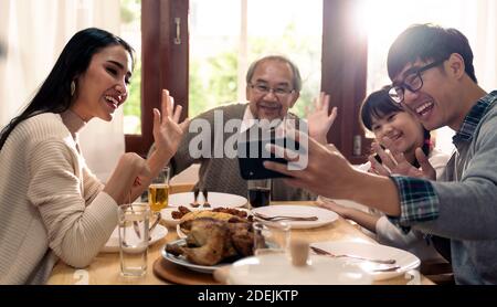 Glücklich asiatische multigenerational Familie von Papa Mama Tochter Mädchen und Großvater Selfie zusammen vor dem Essen Mittagessen zusammen zu Hause. Glückliche Familie Stockfoto