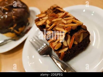 Ein Stück Schokolade Brownie Kuchen gekrönt mit Slide Mandeln. Stockfoto