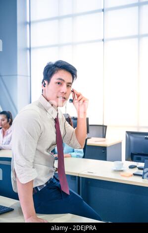 Junge Kundendienstmitarbeiter mit Headsets und Computer arbeiten im Büro. Professionelles Bedienkonzept. Stockfoto