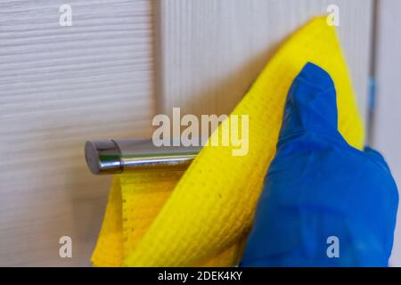 Reinigung der Wohnung oder des Büros.antiseptische Behandlung der Türgriffe während einer Virusepidemie. Stockfoto