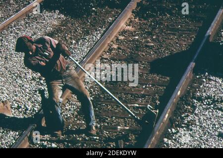 Southern Railway Right-of-Way-Arbeiter jagt eine Schiene, so dass Binder ersetzt werden können. Ca. 1974 Stockfoto