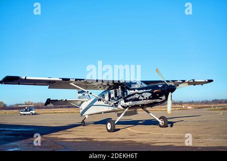 Flugzeug auf der Landebahn in den Strahlen der Sonne. Sonnenuntergang am Flughafen. Stockfoto