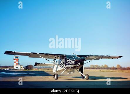 Flugzeug auf der Landebahn in den Strahlen der Sonne. Sonnenuntergang am Flughafen. Stockfoto