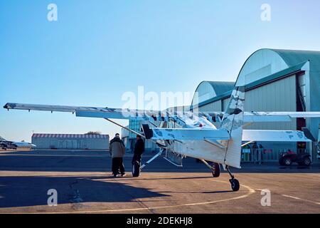 Flugzeug auf der Landebahn in den Strahlen der Sonne. Sonnenuntergang am Flughafen. Stockfoto