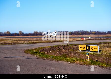 Flugzeug auf der Landebahn in den Strahlen der Sonne. Sonnenuntergang am Flughafen. Stockfoto