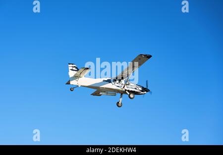 Flugzeug auf der Landebahn in den Strahlen der Sonne. Sonnenuntergang am Flughafen. Stockfoto