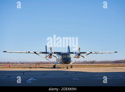 Flugzeug auf der Landebahn in den Strahlen der Sonne. Sonnenuntergang am Flughafen. Stockfoto