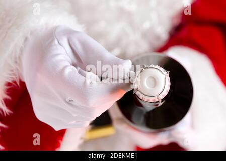 Mann im weihnachtsmann Kostüm öffnet eine Flasche Champagner Stockfoto