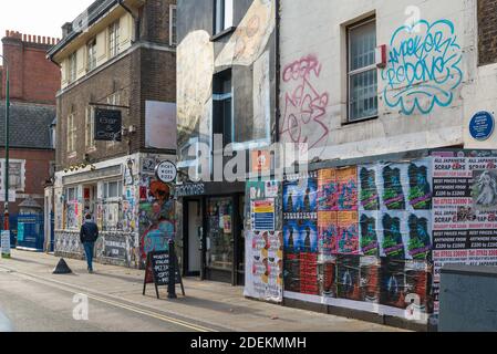 Picky Wops Pizza Shop und die jetzt verfallene ehemalige 7 Sterne Bar und Cafe in Brick Lane, Spitalfields, London, England, Großbritannien Stockfoto