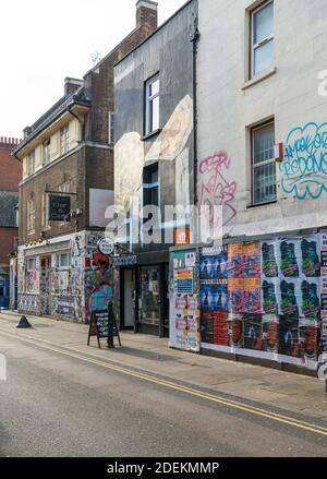 Picky Wops Pizza Shop und die jetzt verfallene ehemalige 7 Sterne Bar und Cafe in Brick Lane, Spitalfields, London, England, Großbritannien Stockfoto