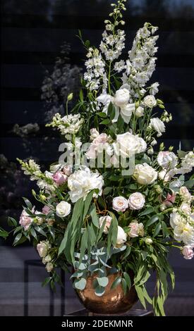 Beeindruckendes floristisches Bouquet von weißen Rosen und Delphinium - grün Drehen Stockfoto