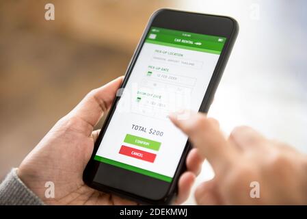 Frau, die Online-Zahlung für die Reservierung von Mietwagen bestätigt Auf dem mobilen Smartphone Stockfoto