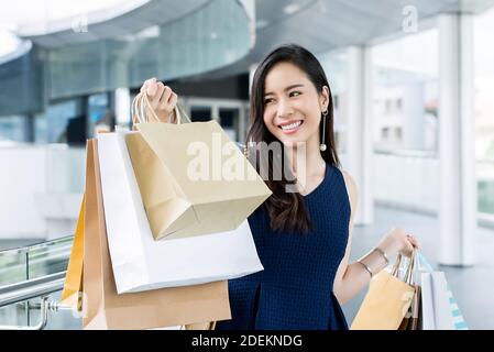 Glücklich schöne junge asiatische Frau genießen Shopping in der Stadt Während der Weihnachtszeit Stockfoto