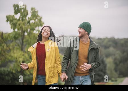 Junges Paar, das im Park spazierengeht und sich glücklich fühlt Stockfoto