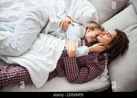 Glücklich junges Paar in der Liebe Kuscheln im Bett Stockfoto