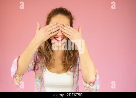 Schöne junge Frau kaukasischen isoliert bedeckt Augen mit Händen, lächelt breit warten auf eine Überraschung. Stockfoto