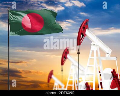 Ölbohrinseln vor dem Hintergrund des bunten Himmels und einer Fahnenstange mit der Flagge von Bangladesch. Das Konzept der Ölproduktion, Mineralien, Entwicklung von Stockfoto