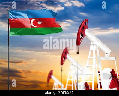Ölbohrinseln vor dem Hintergrund des bunten Himmels und einer Fahnenstange mit der Flagge Aserbaidschans. Das Konzept der Ölproduktion, Mineralien, Entwicklung von Stockfoto