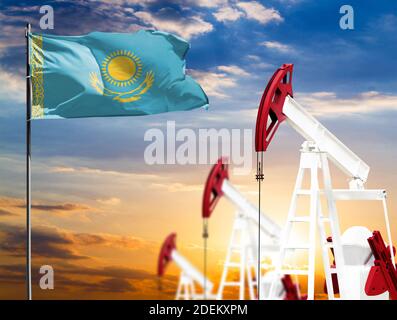 Ölbohrinseln vor dem Hintergrund des bunten Himmels und einer Fahnenstange mit der Flagge Kasachstans. Das Konzept der Ölproduktion, Mineralien, Entwicklung von Stockfoto