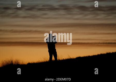 Newtown Linford, Leicestershire, Großbritannien. Dezember 2020. Wetter in Großbritannien. Ein Mann fotografiert den Sonnenaufgang im Bradgate Park am ersten Tag des meteorologischen Winters in Großbritannien. Credit Darren Staples/Alamy Live News. Stockfoto