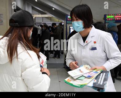 Peking, China. Dezember 2020. Ein medizinisches Personal (R) übergibt AIDS-Präventionsbroschüren während einer AIDS-Sensibilisierungskampagne, die anlässlich des Welt-Aids-Tages im Haidian Krankenhaus in Peking, der Hauptstadt Chinas, am 1. Dezember 2020 stattfand. Quelle: Ren Chao/Xinhua/Alamy Live News Stockfoto