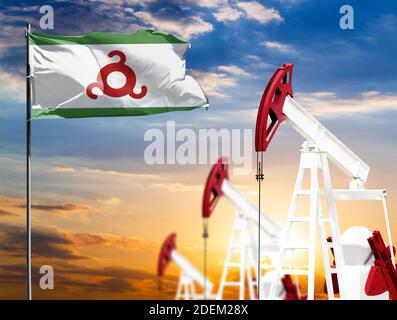 Ölbohrinseln vor dem Hintergrund des bunten Himmels und einer Fahnenstange mit der Flagge von Inguschetien. Das Konzept der Ölproduktion, Mineralien, Entwicklung von Stockfoto