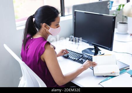 Kaukasische Frau trägt Gesichtsmaske in einem Büro Stockfoto