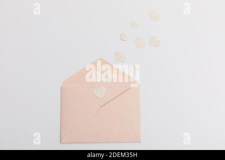 Rosa Umschlag und mehrere Herzen mit Text auf weißem Hintergrund Stockfoto
