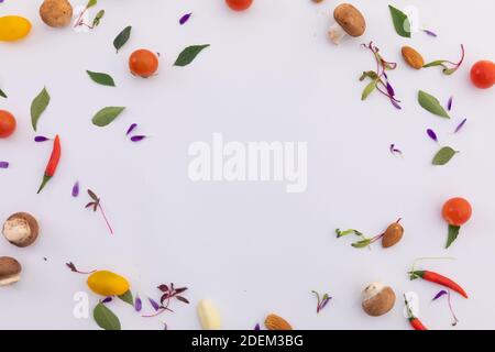 Frisches Gemüse und Blätter im Kreis auf weißem Hintergrund angeordnet Stockfoto