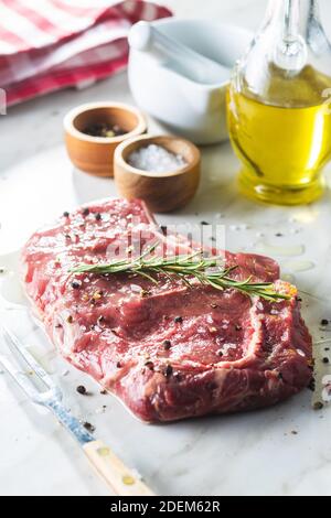 Geschnittenes rohes Ribeye Steak auf einem weißen Küchentisch. Stockfoto