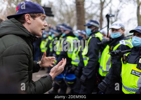 Anti-Lockdown Protest, Hyde Park, London, 28. November 2020. Ein Protestler unterhält sich mit Polizisten, die eine Blockade aufrechterhalten. Stockfoto