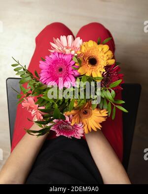 Mädchen Hände halten schöne bunte Blumen Bouquet von Gerberas, Draufsicht. Florale Komposition. Stockfoto