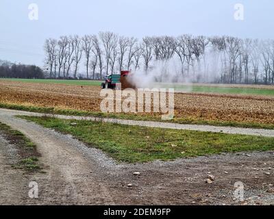 Österreich, Landwirt auf Traktor mit landwirtschaftlicher Feldarbeit, Düngerausbringung Stockfoto