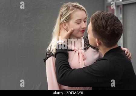 Junges Paar küssen sitzen auf Bank an der Bushaltestelle in Regen Stockfoto