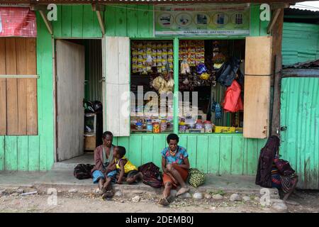 Frauen und Kinder sitzen vor einem Geschäft in Wamena, West Papua, Indonesien. Stockfoto